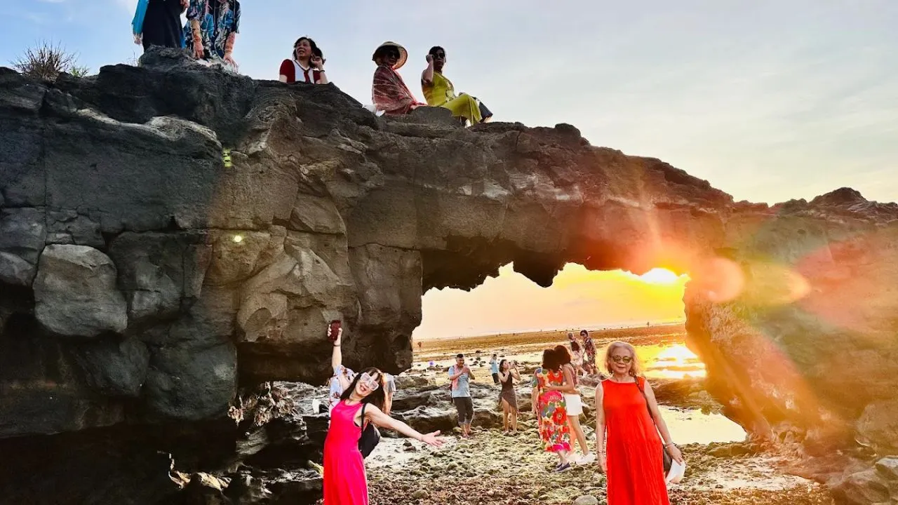 Cổng Tò Vò lúc hoàng hôn, sóng biển vỗ vào đá bazan, ánh nắng vàng cam phản chiếu trên mặt nước