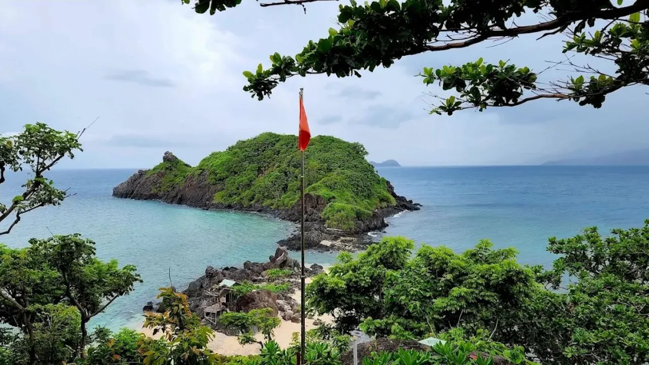 A panoramic view of Hon Tre Lon from above, clearly showing two islands connected by a white sandbar