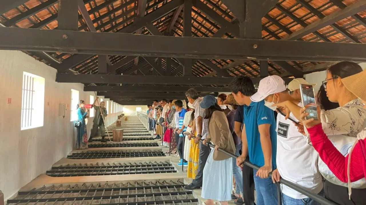 Du khách nghe thuyết minh về chuồng cọp
