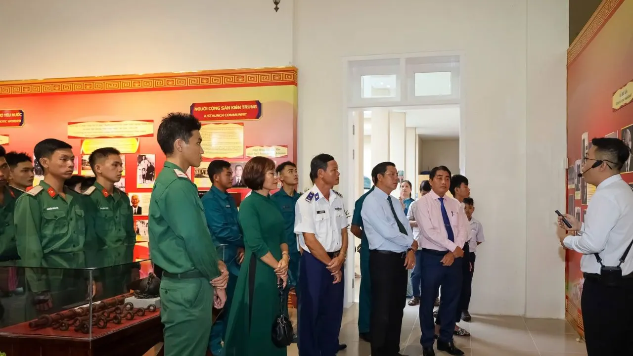 Tủ kính trưng bày xiềng xích, còng sắt cạnh ảnh tư liệu đen trắng về tù chính trị